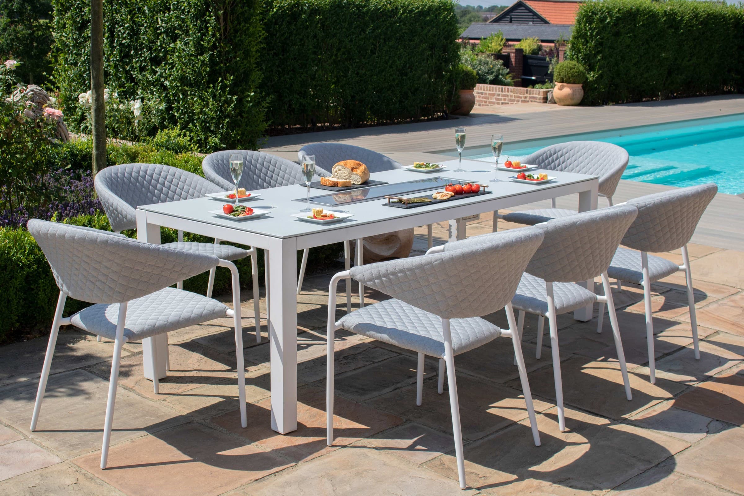 Alomé outdoor dining furniture beside a swimming pool