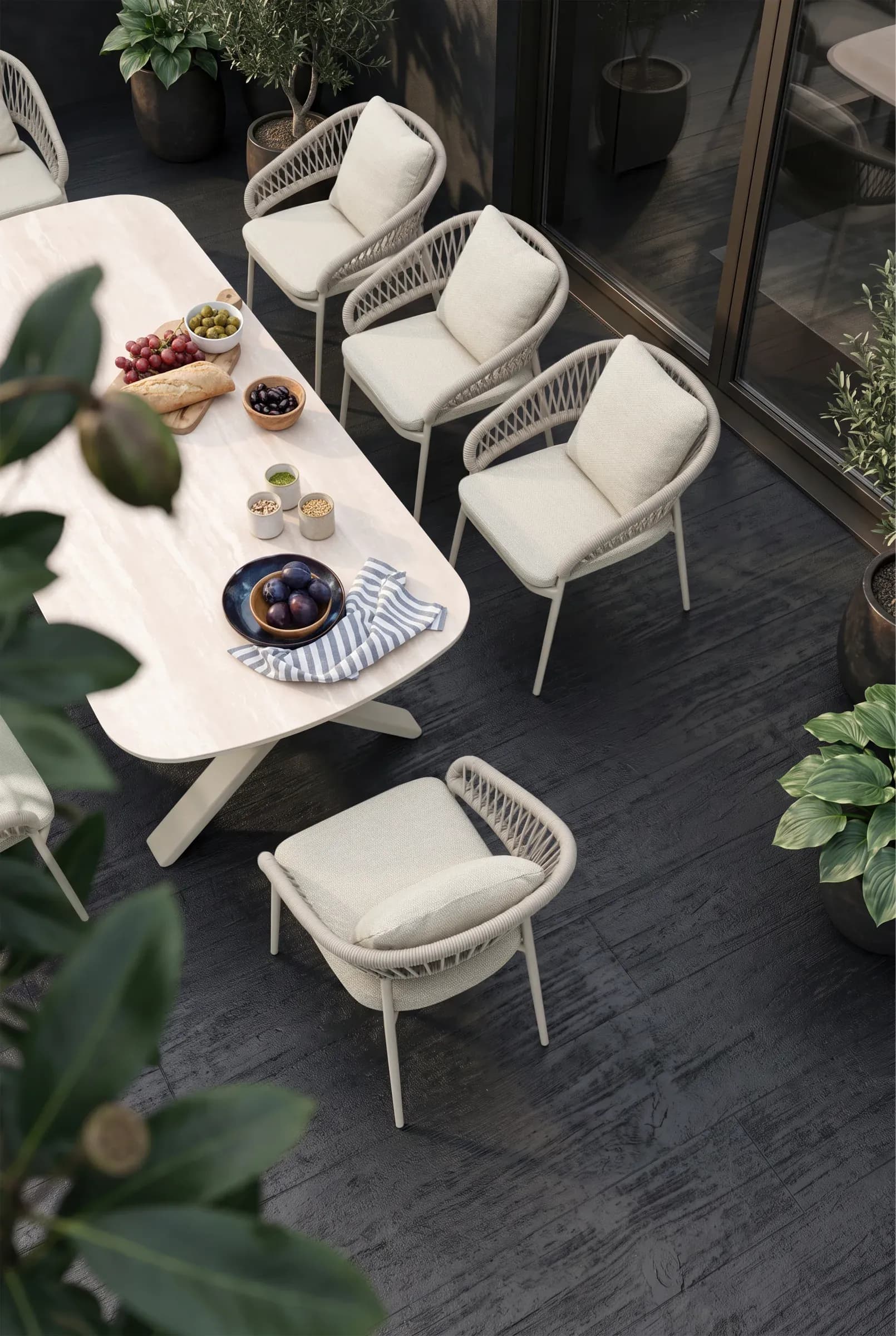 Loom Dining Chairs arranged around a dining table on a planted terrace